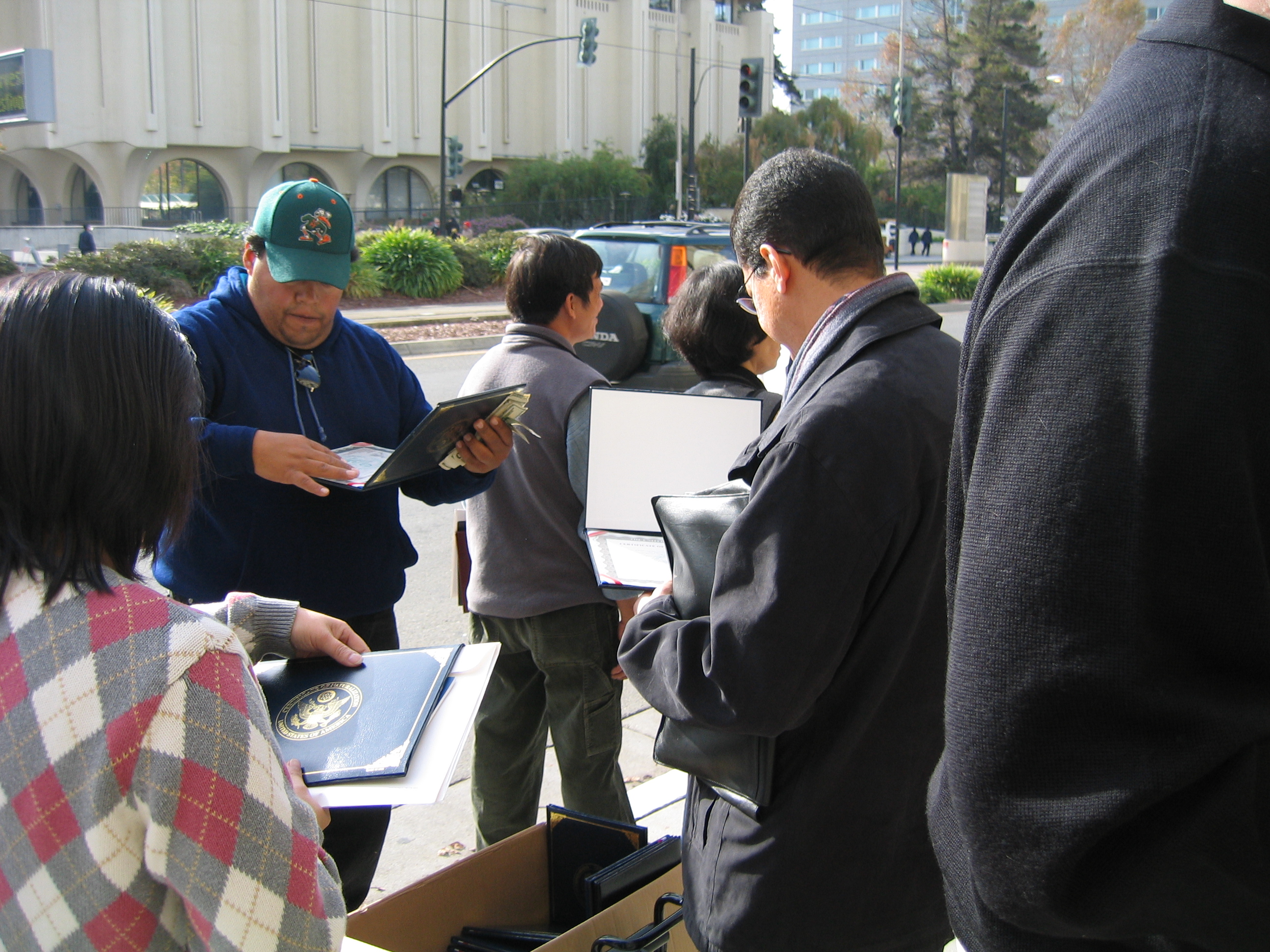 New citizens examining their certificates outside the auditorium