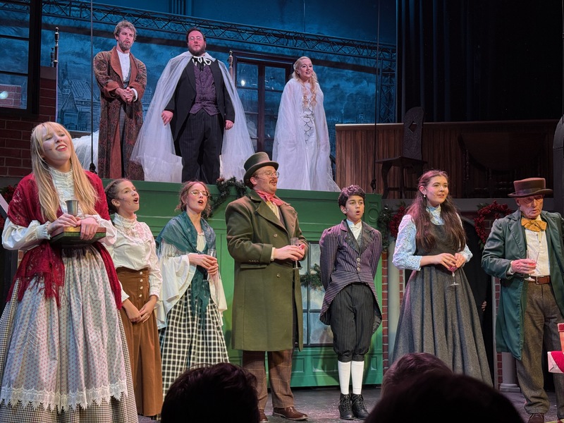 Fitz as Young Jacob Marley, singing with the ensemble in Victorian costume